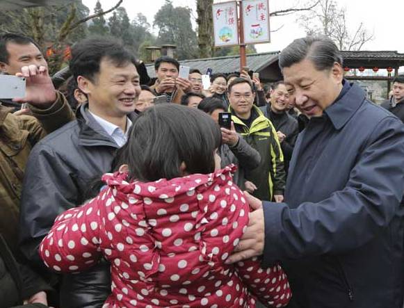 习近平在井冈山八角楼革命旧址群参观时,与村民们互动
